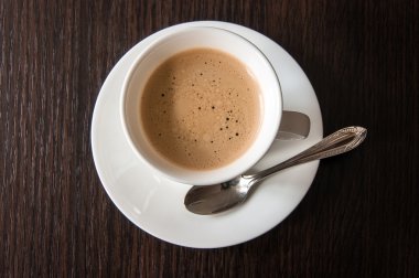 Tahta bir masada bir fincan kahve.