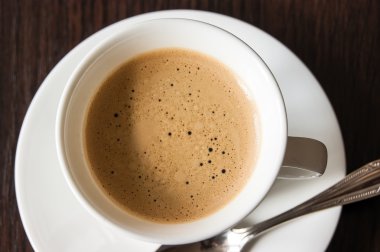 Tahta bir masada bir fincan kahve.