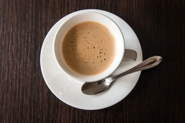 Tahta bir masada bir fincan kahve.