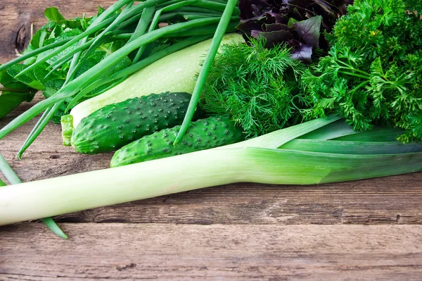 Verse groene groenten op houten tafel — Stockfoto