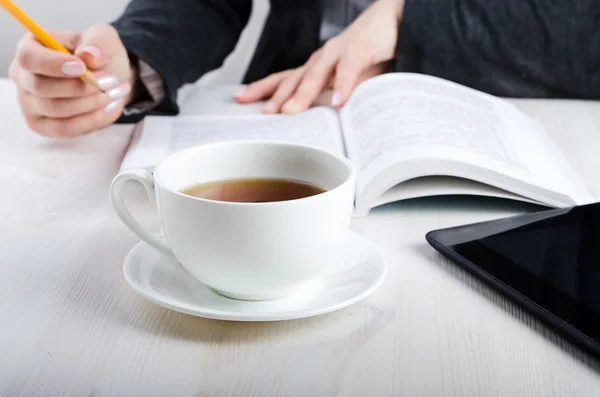 Pracownik biurowy, czytając książkę i picie herbaty — Zdjęcie stockowe