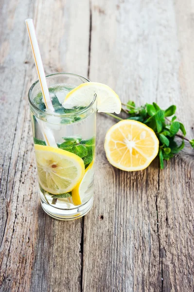 Lemonade with fresh lemon and mint in glass on wooden background — Stock Photo, Image