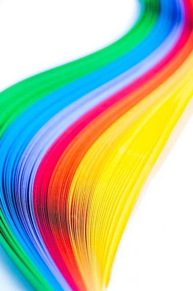 Rainbow colored quilling paper laid out in waves and shapes — Stock Photo, Image