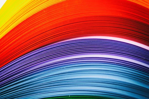 Rainbow colored quilling paper laid out in waves and shapes — Stock Photo, Image