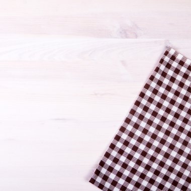 ağartılmış ahşap masa üzerinde kahverengi katlanmış masa örtüsü