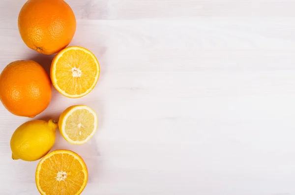 Naranjas frescas y limones sobre fondo de madera — Foto de Stock