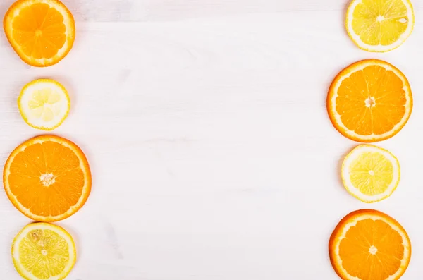 Naranjas frescas y limones sobre fondo de madera — Foto de Stock