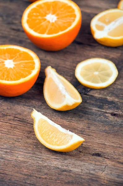 Naranjas frescas y limones sobre fondo de madera —  Fotos de Stock