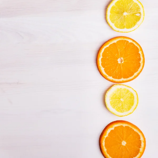 Verse sinaasappelen en citroenen op houten achtergrond — Stockfoto