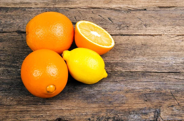 Arance fresche e limoni su fondo di legno — Foto Stock