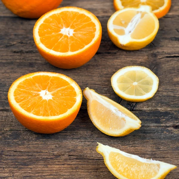 Naranjas frescas y limones sobre fondo de madera —  Fotos de Stock