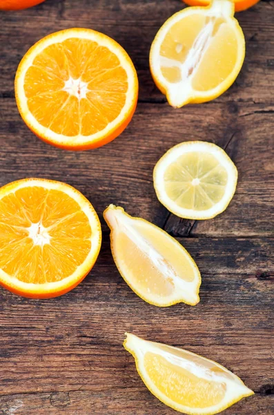 Verse sinaasappelen en citroenen op houten achtergrond — Stockfoto