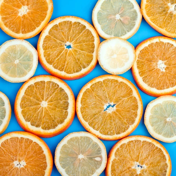 Rodaja de naranja y limón sobre un fondo azul —  Fotos de Stock