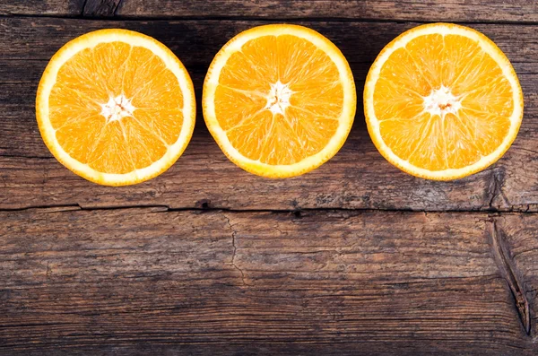 Tuoreet appelsiinit puupohjalla — kuvapankkivalokuva