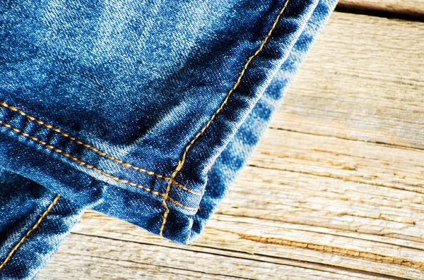 Jeans bleus sur vieille surface en bois — Photo