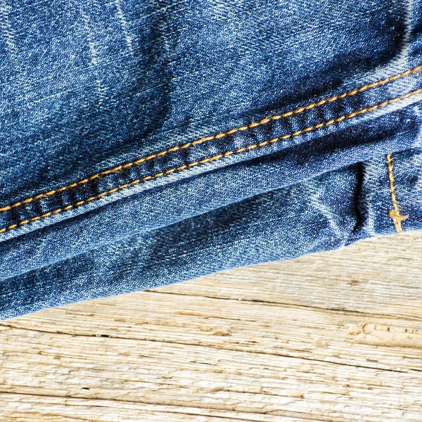 Голубые джинсы на старой деревянной поверхности — стоковое фото