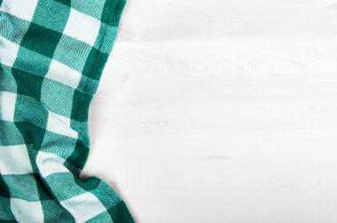 ağartılmış ahşap masa üzerinde yeşil katlanmış masa örtüsü