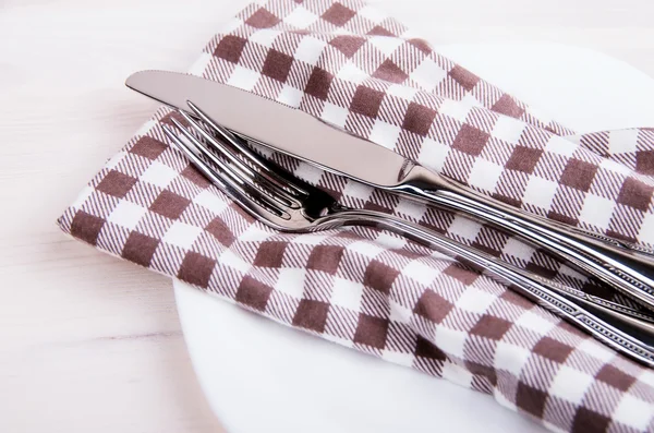 Knife and fork on a checkered napkin — Stock Photo, Image