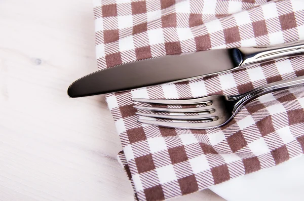 Couteau et fourchette sur une serviette à carreaux — Photo