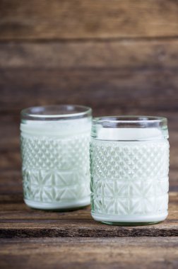 Tahta bir masada bir bardak süt.