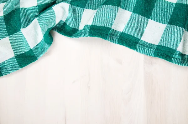 Green folded tablecloth over bleached wooden table — Stock Photo, Image