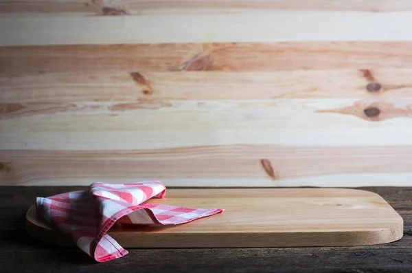 Leeres Schneidebrett mit Serviette auf einem notleidenden Grunge-Holztisch — Stockfoto