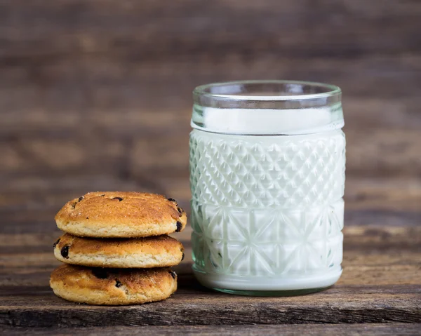 Tasty cookies and glass of milk on rustic wooden background — Stock Photo, Image