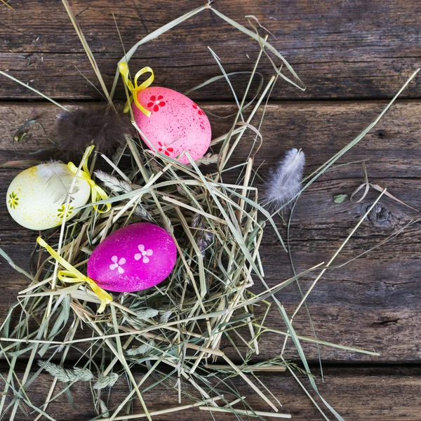 Huevos de Pascua en nido sobre tablones rústicos de madera —  Fotos de Stock