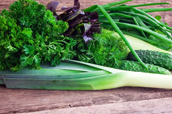 Verse groene groenten op een houten ondergrond — Stockfoto