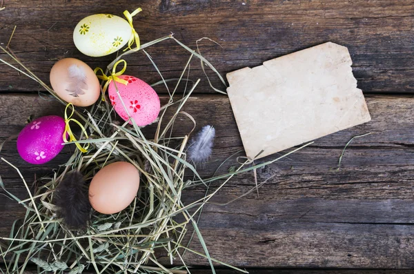 Huevos de Pascua en nido sobre tablones rústicos de madera —  Fotos de Stock