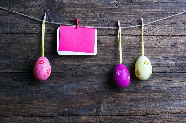 Paskalya yumurtaları ahşap zemin, Vintage üzerine bir çizgi üzerinde asılı Paskalya etiket — Stok fotoğraf