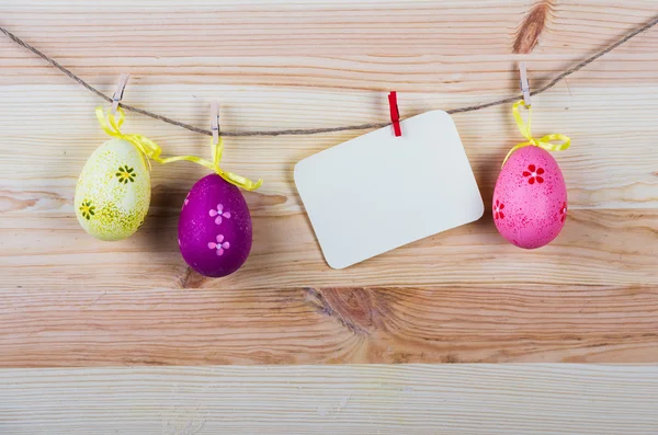 Etiqueta de Pascua colgando en una línea con huevos de Pascua en el fondo de madera, Vintage — Foto de Stock