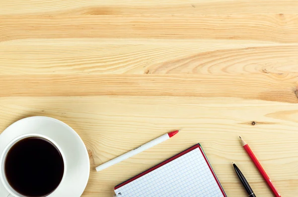 Notatnik pióro i filiżankę kawy w stół z drewna — Zdjęcie stockowe