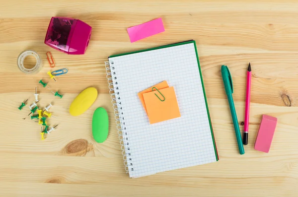 Cadernos, canetas e adesivos em fundo de madeira — Fotografia de Stock