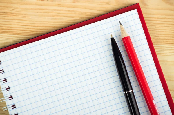 Cuaderno en blanco con pluma y lápiz sobre mesa de madera — Foto de Stock