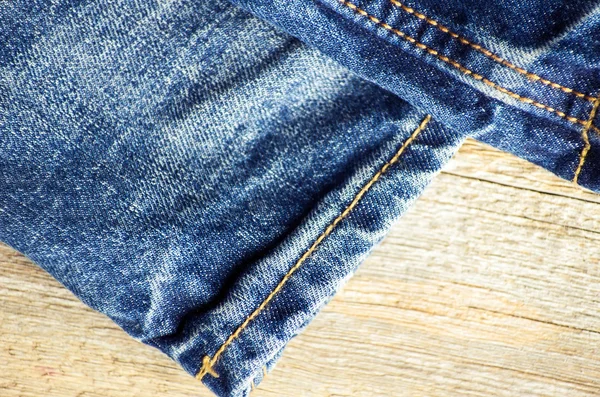 Blue jeans on old wooden surface — Stock Photo, Image