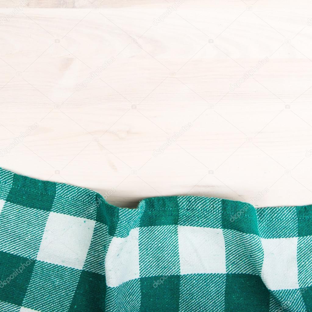 green folded tablecloth over bleached wooden table