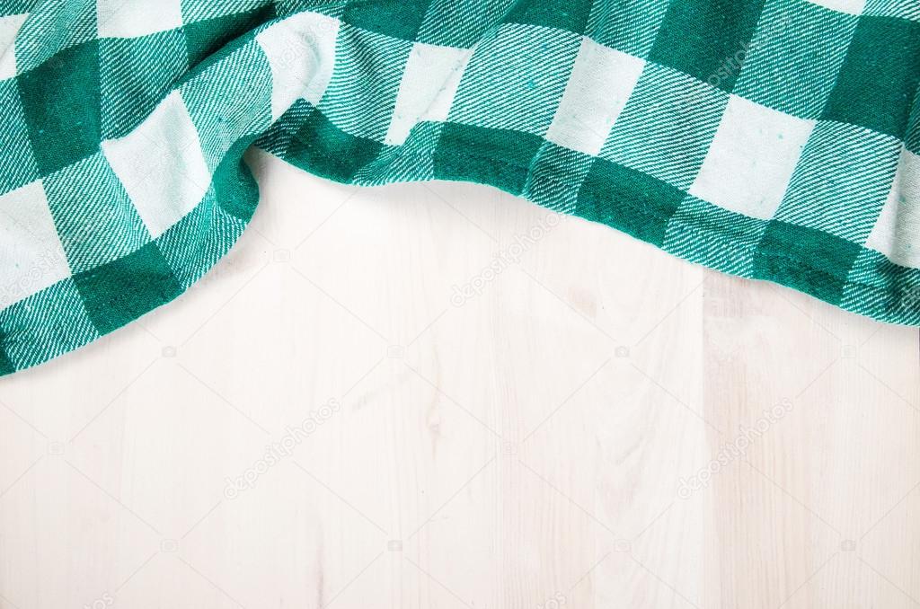 green folded tablecloth over bleached wooden table