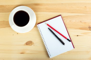 defter kalem ve ahşap masa kahve fincan