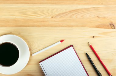 defter kalem ve ahşap masa kahve fincan