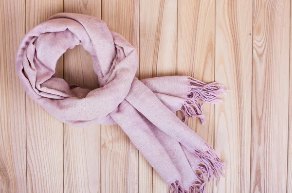 在一个木制的背景上的粉色围巾围巾 — 图库照片