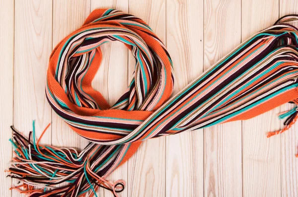 Помаранчевий смугастий шарф на дерев'яному фоні — стокове фото