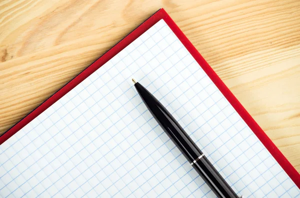 Cuaderno en blanco con pluma y lápiz sobre mesa de madera — Foto de Stock