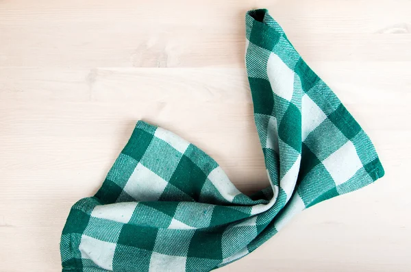 Green folded tablecloth over bleached wooden table — Stock Photo, Image