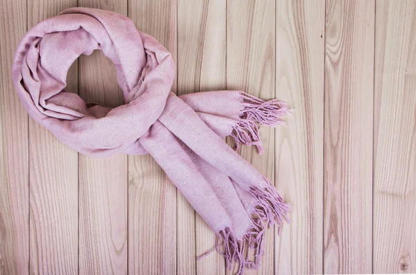 在一个木制的背景上的粉色围巾围巾 — 图库照片