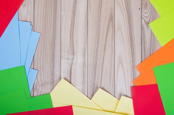 Papel de diferentes colores sobre fondo de madera — Foto de Stock