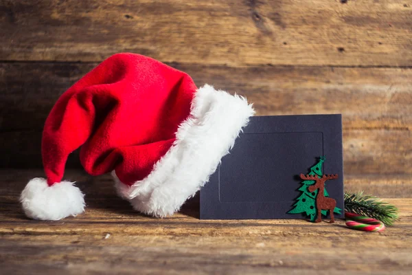 Cartões de Natal e presentes com chapéus de Santa em fundo de madeira w — Fotografia de Stock