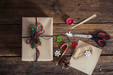 Şeker kamışı, çam dalları, mum, koni ahşap bir zemin üzerine Noel hediyeleri.