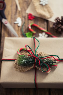 Şeker kamışı, çam dalları, mum, koni ahşap bir zemin üzerine Noel hediyeleri.