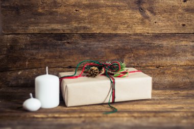 Şeker kamışı, çam dalları, mum, koni ahşap bir zemin üzerine Noel hediyeleri.